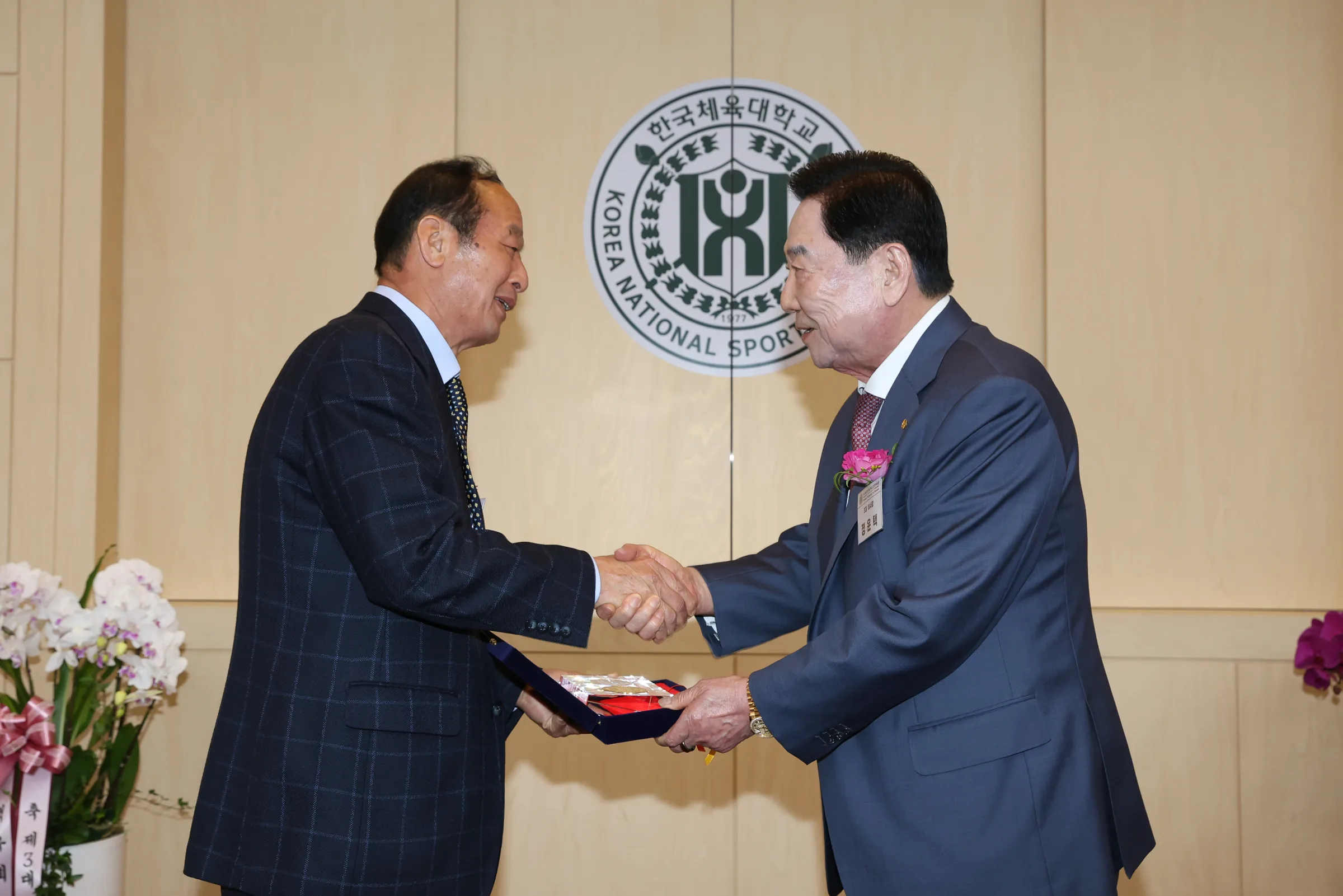 취임식에서 기념 전달 후 악수하는 참석자와 정운택 이사장